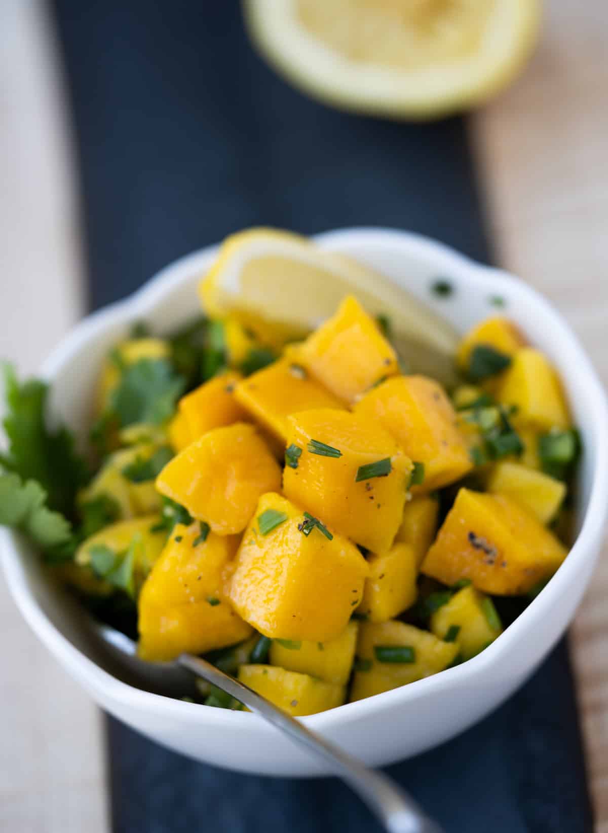 Mango mint salsa in white bowl with spoon