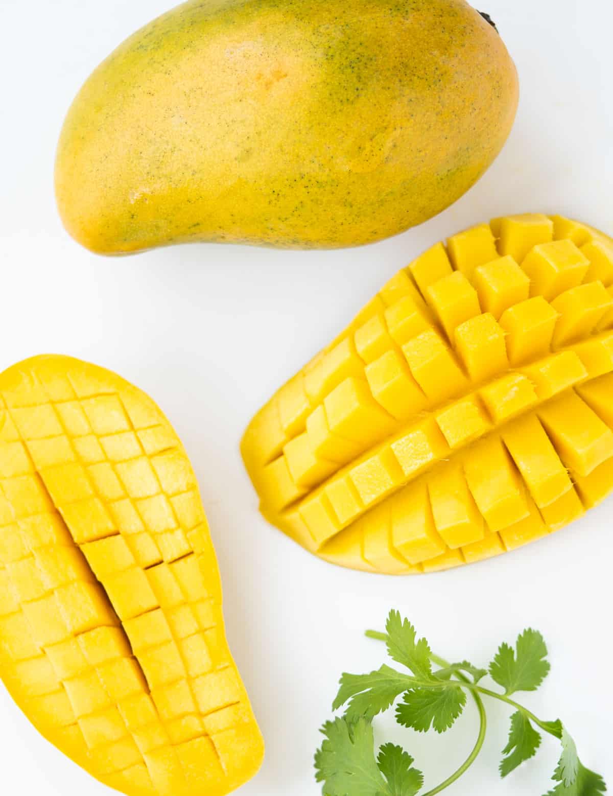 Mango cut in half with cut marks to show how to dice