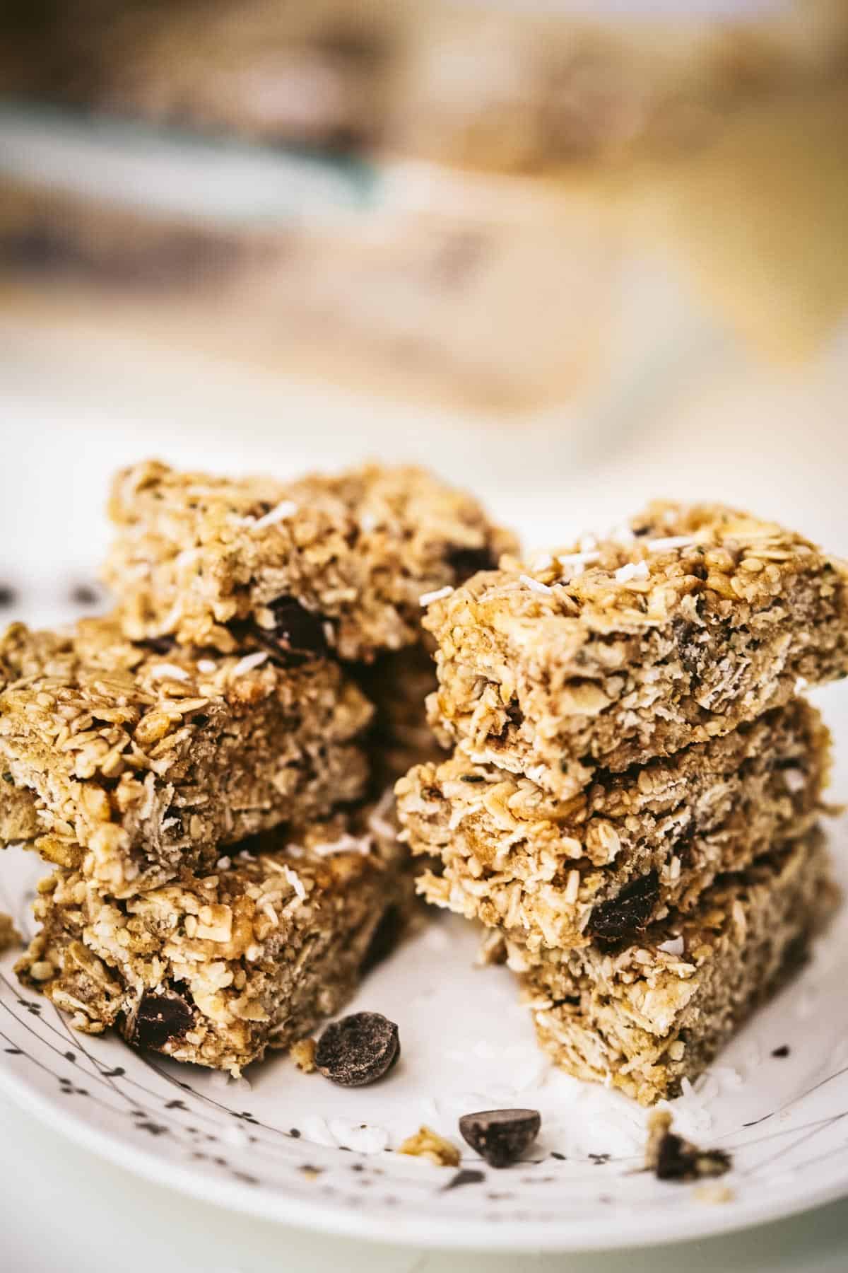 Chewy chocolate chip granola bars in three stacks on a plate