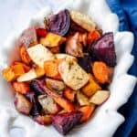 assorted roasted root vegetables in a white dish.