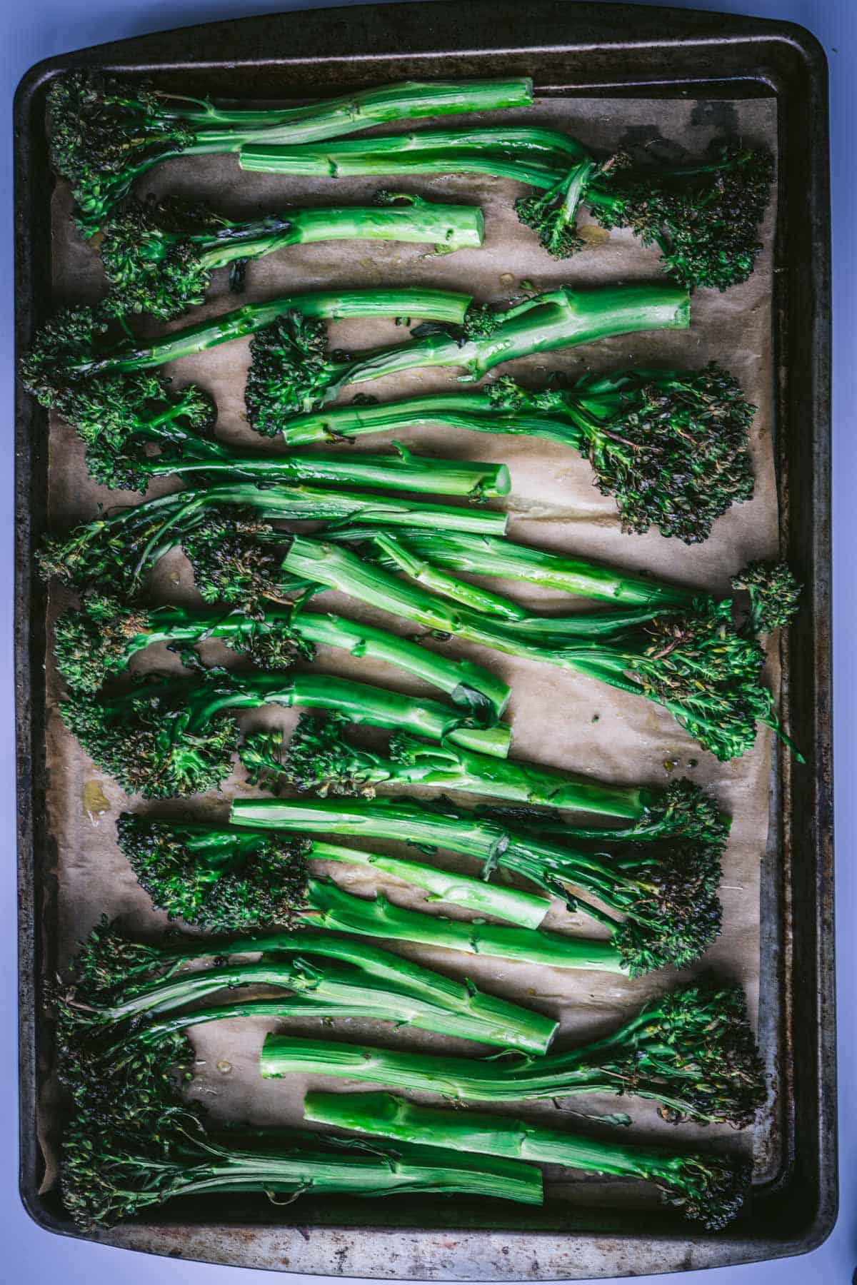 roasted broccolini on baking tray lined with unbleached parchment paper