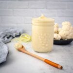 cauliflower cream sauce in mason jar with wood spoon