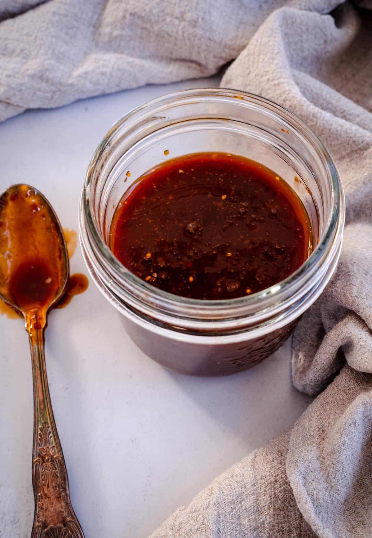 Easy sticky teriyaki sauce in mason jar with spoon next to it.