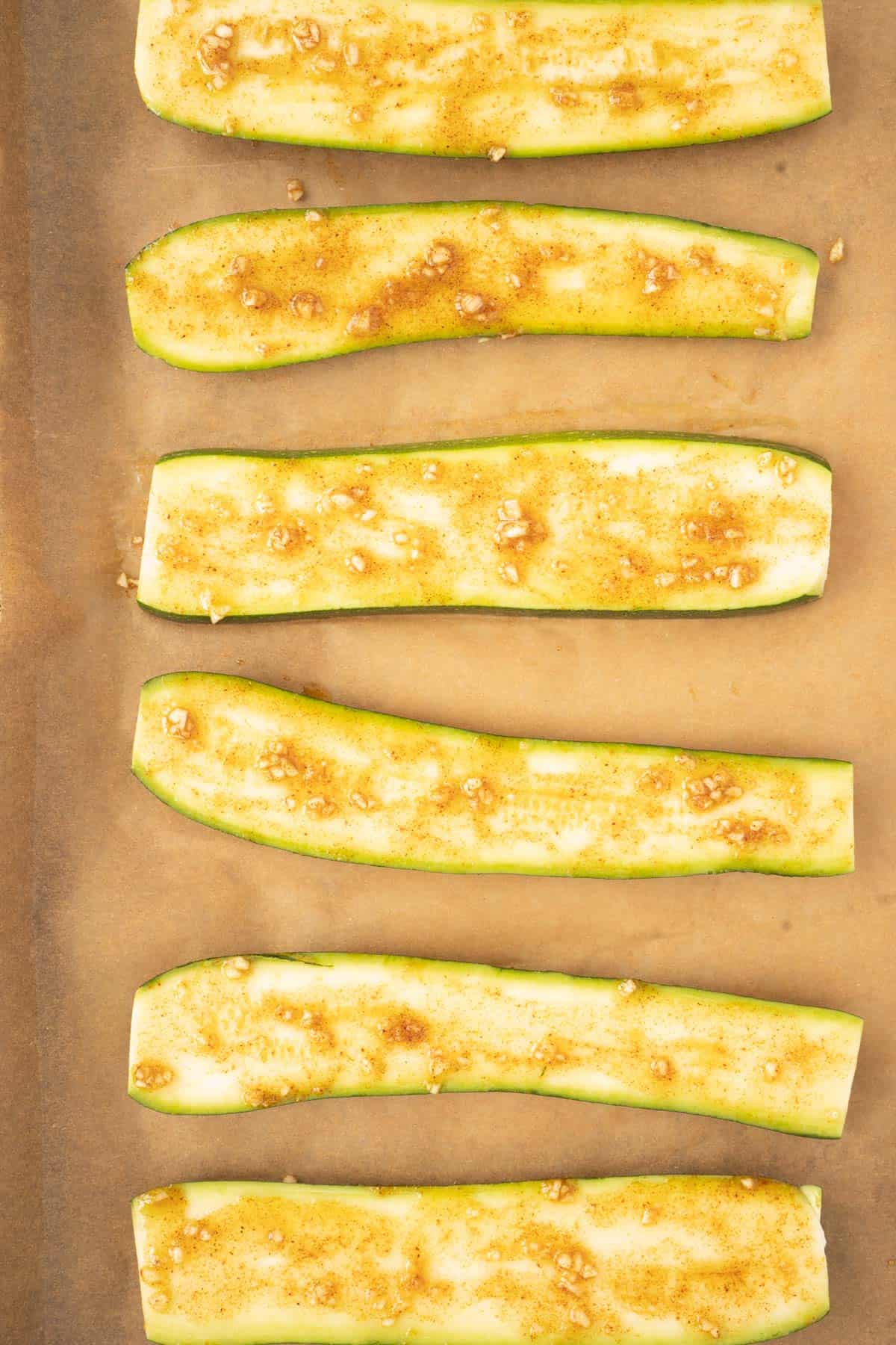 zucchini slices on parchment with garlic spice 