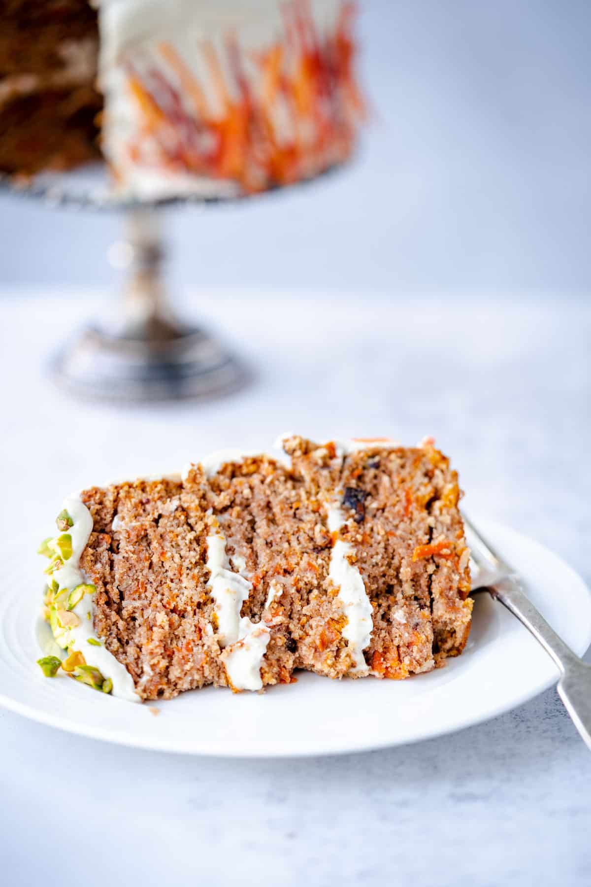 best healthy low sugar carrot cake slice on white plate with fork.