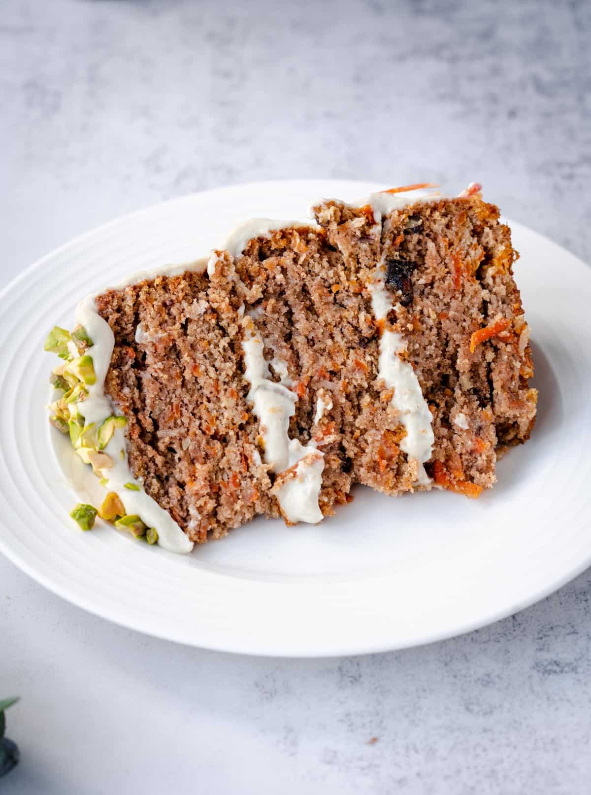 best healthy low sugar carrot cake slice on white pate.