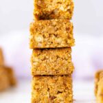 carrot cake oatmeal nut breakfast bars stacked with a bite taken out.