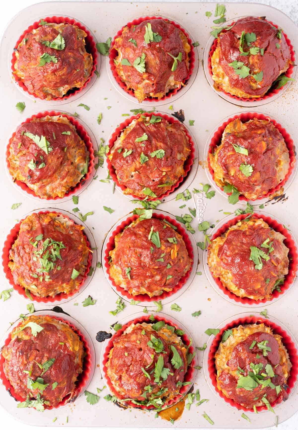 process shot of easy chicken muffins in muffin tin baked and sprinkled with cilantro
