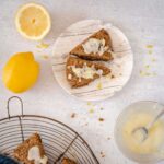 lemon poppy seed scones on a plate with glaze in a bowl
