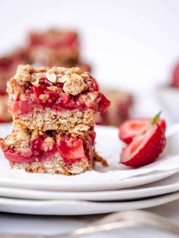 two strawberry crumble bars on white plate.