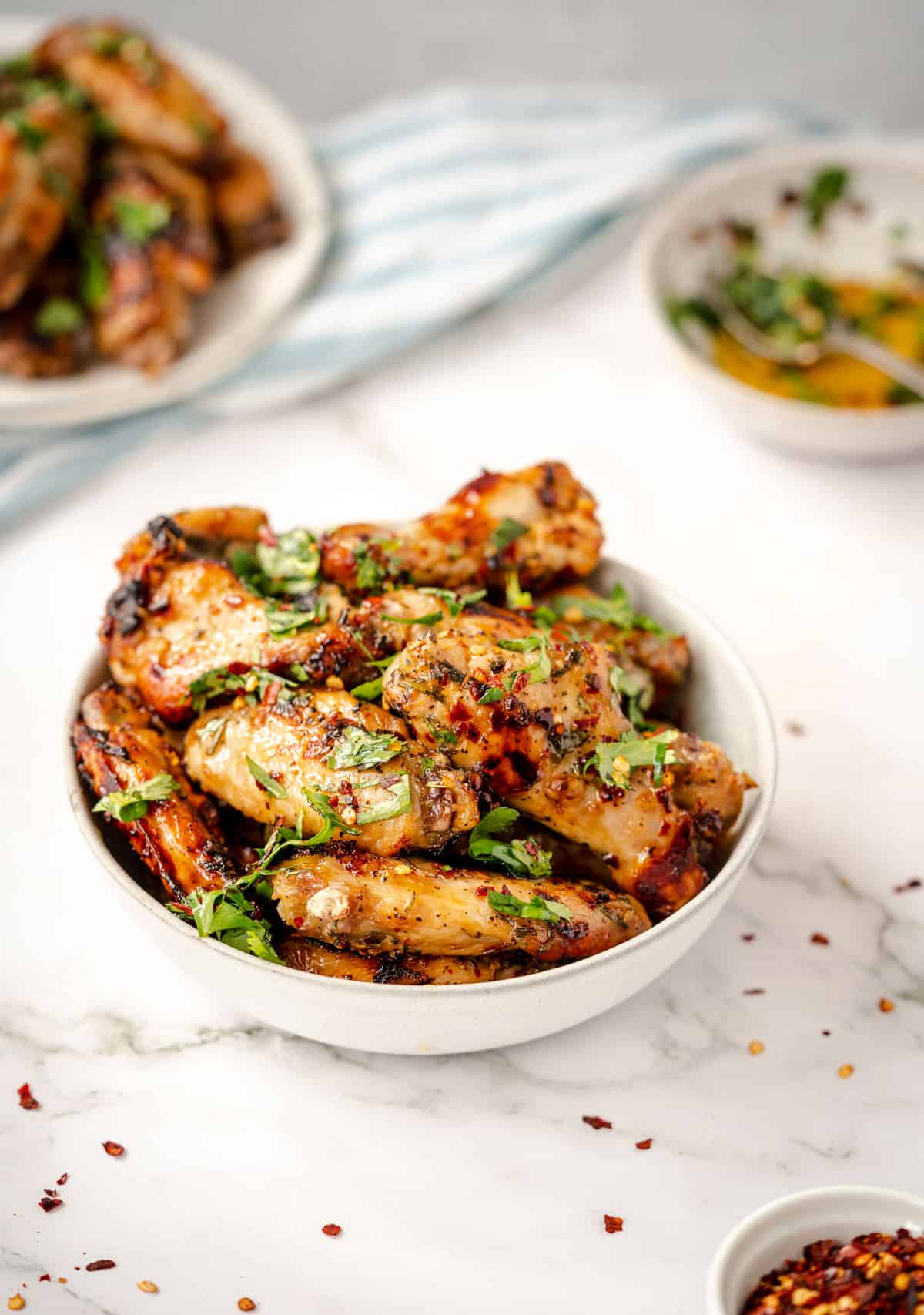 zesty baked italian style chicken wings on 2 plates with dipping sauce.