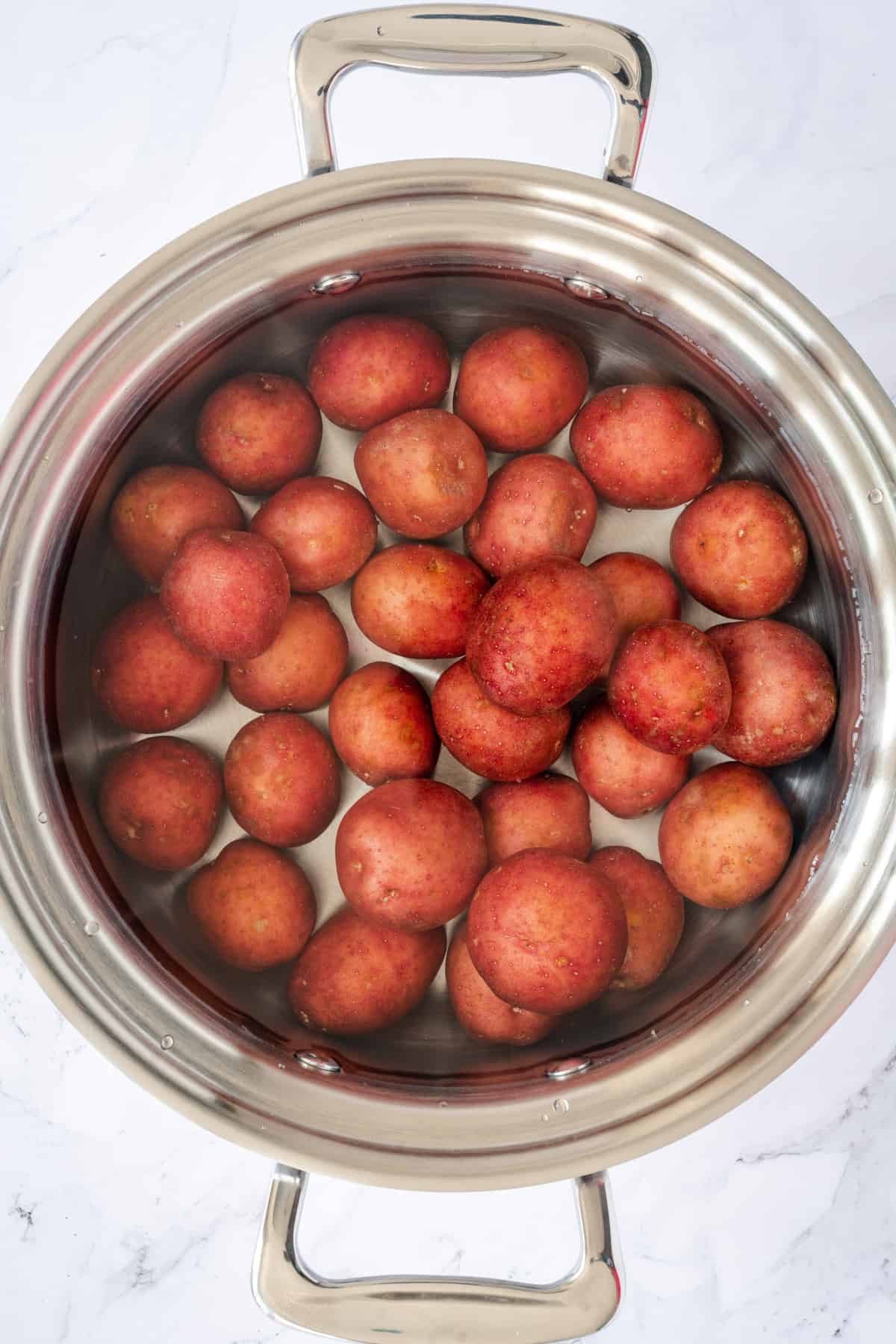 pot with small red potatoes one inch under cold water.