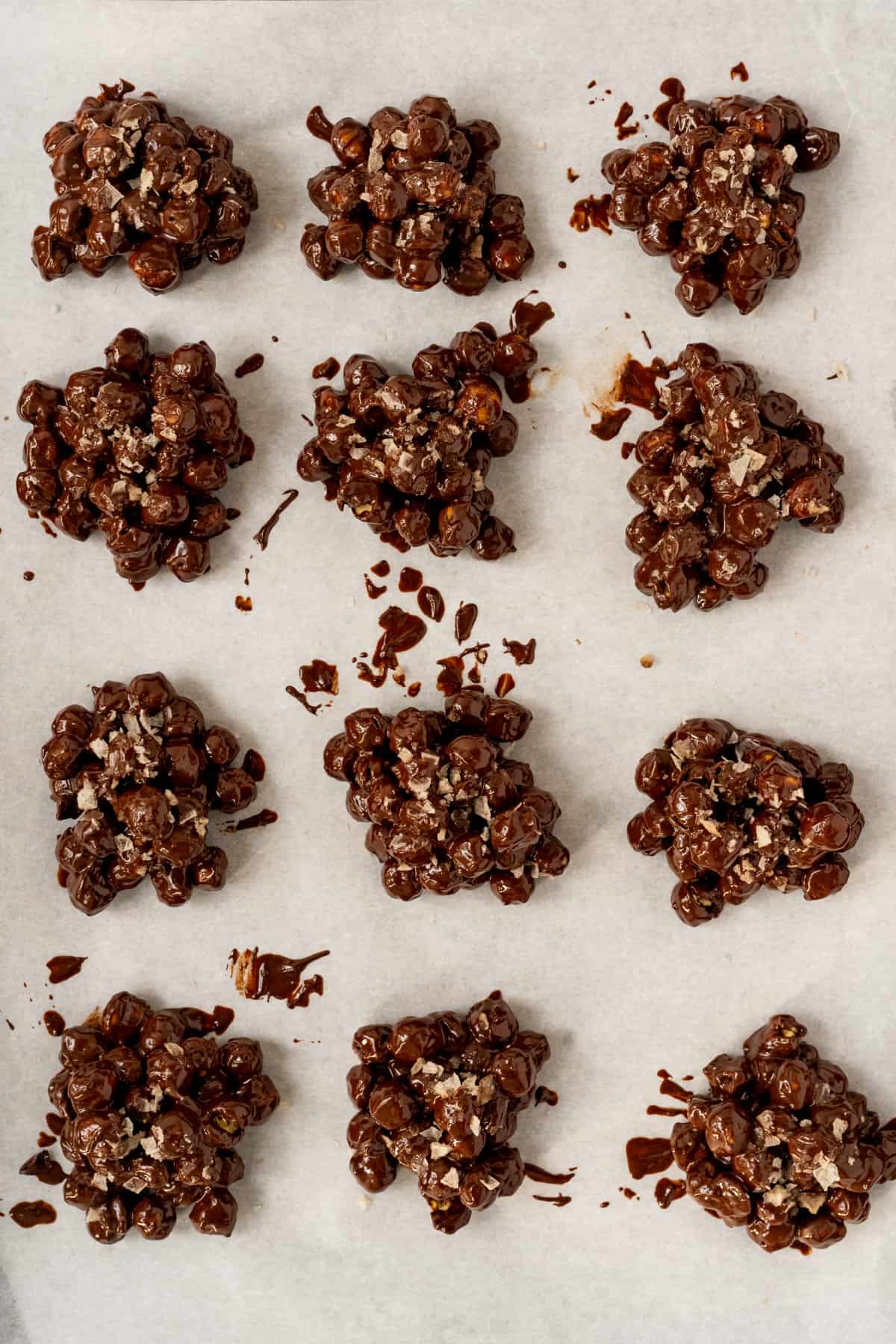 chocolate chickpea clusters sprinkled with corse sea sat on parchment.