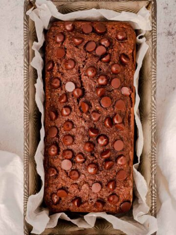 close up of baked chocolate bread in loaf pan.