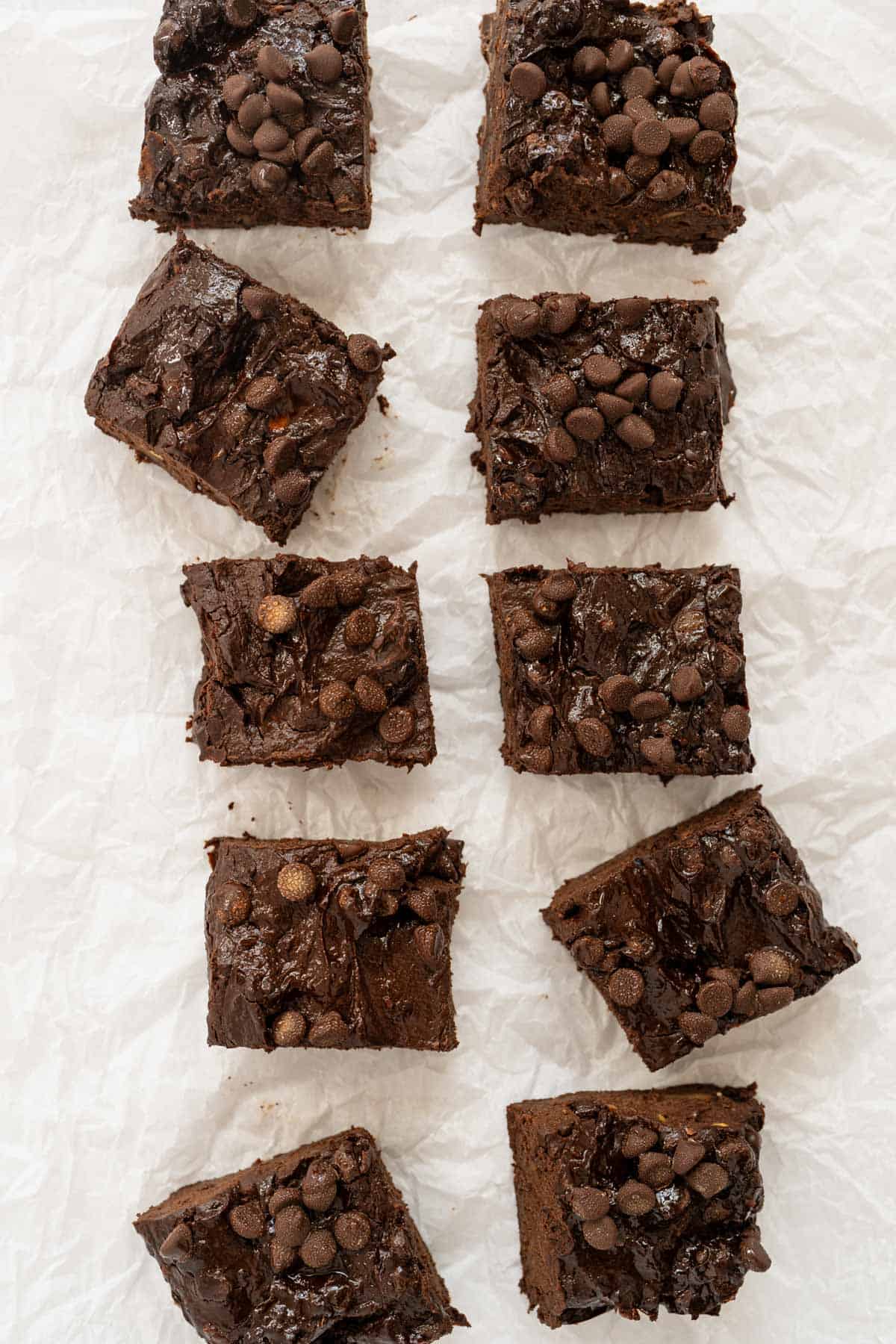 10 cut brownie squares on crumpled parchment paper.