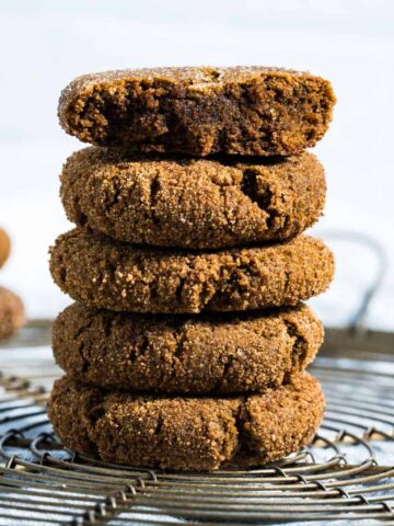 five cookies stacked on round cooling rack sitting on blue napkin, hero shot.
