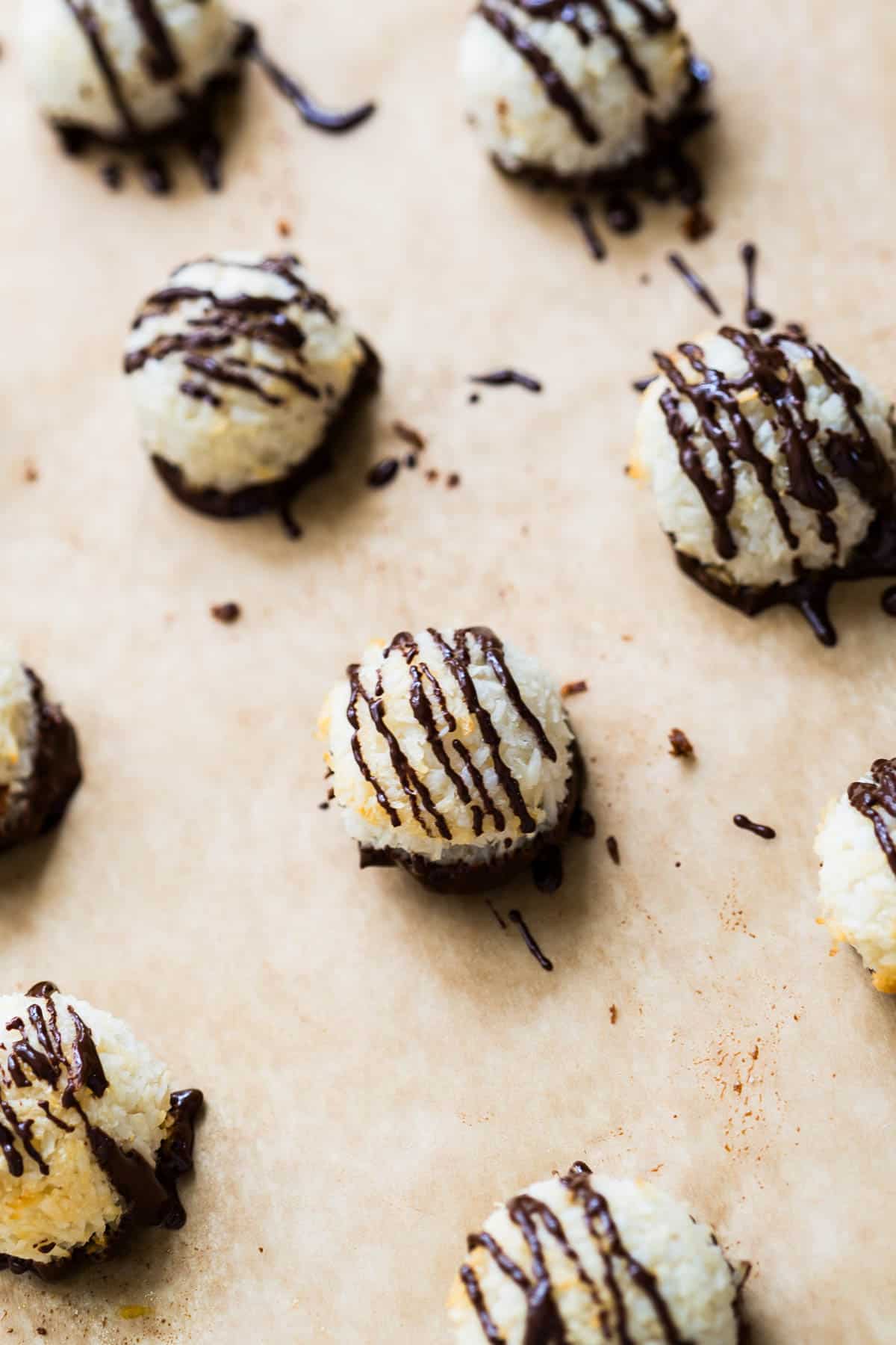 Peppermint coconut macaroons on unbleached parchment paper drizzled with melted dark chocolate.
