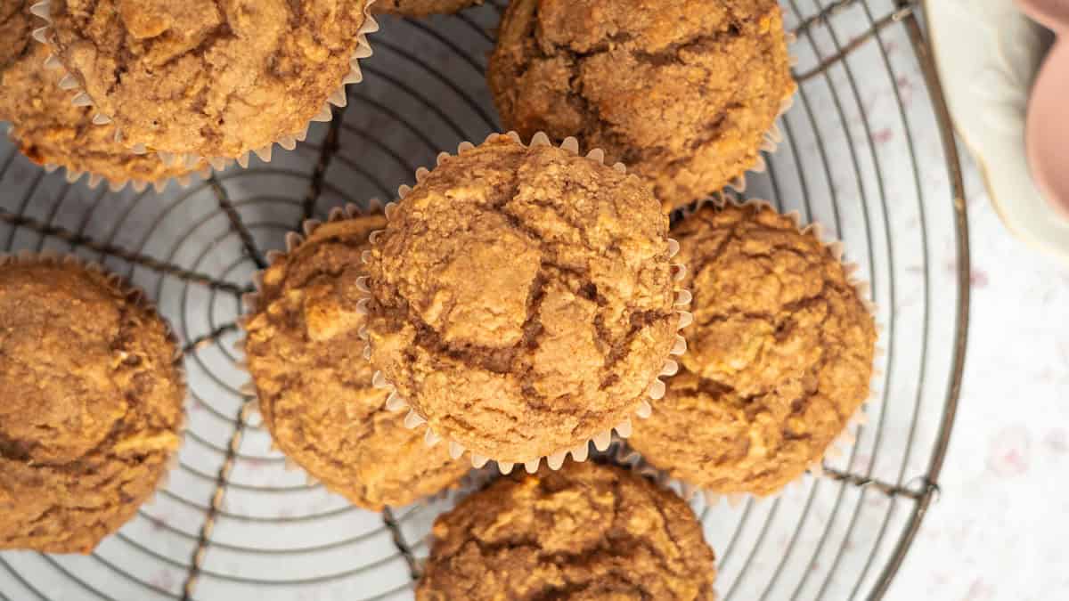 Ginger apple muffins piled on a round cooling rack.