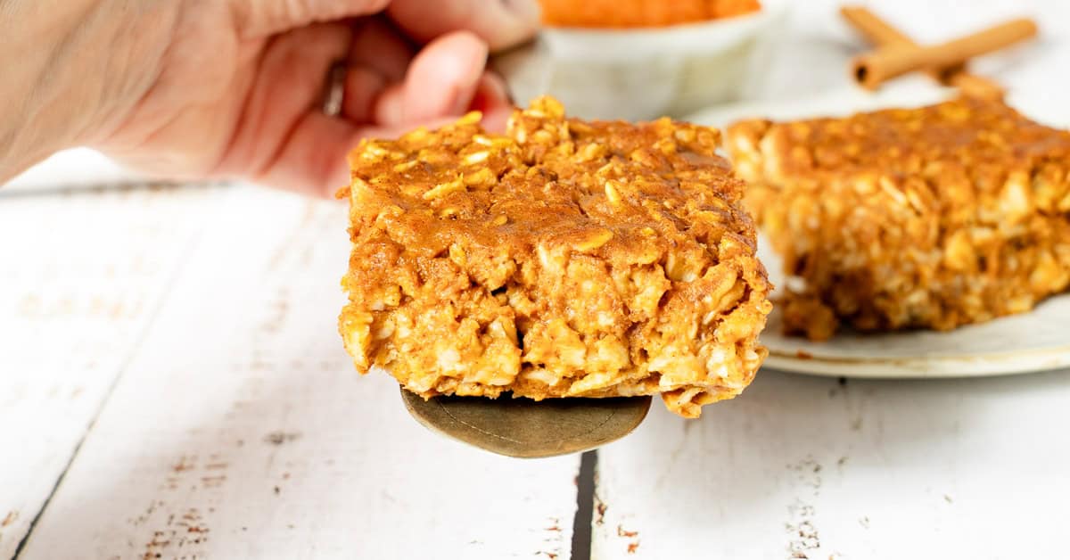 Baked pumpkin oatmeal slice on a serving spoon.